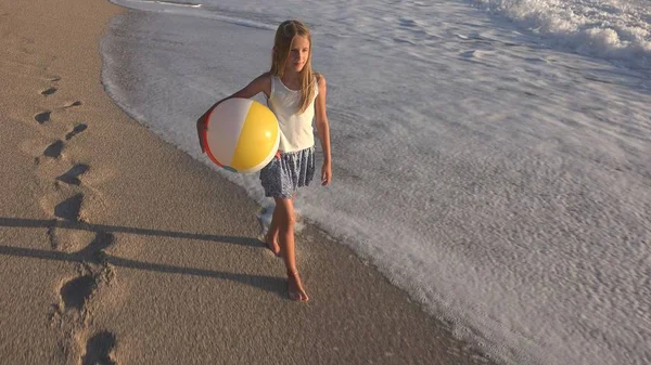 Kumsalda gün batımında, deniz dalgaları kız deniz yürüme çocuk mutlu oynayan çocuk