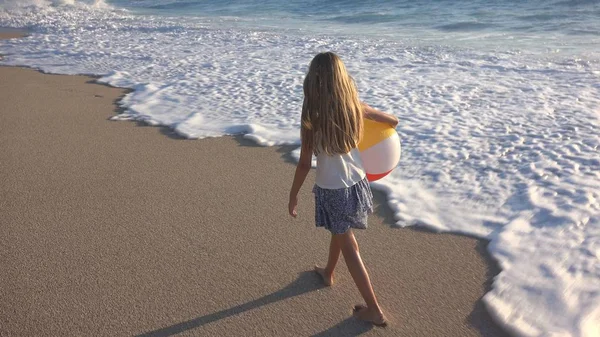 Kumsalda gün batımında, deniz dalgaları kız deniz yürüme çocuk mutlu oynayan çocuk