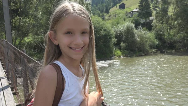 山中では 橋の上の子は子供の川 ストリームを見て女の子を自然の中でハイキング — ストック写真
