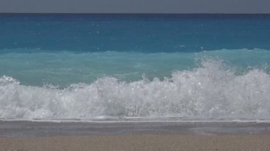 Mavi okyanus dalgalarının güzel dalgalar kumsalda, deniz kıyısı kırma ağır çekimde