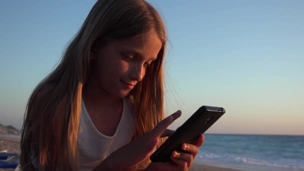 Dziecko Bawiące Się Smartfonie Dziecko Plaży Zachodzie Słońca Dziewczyna Korzystająca — Wideo stockowe