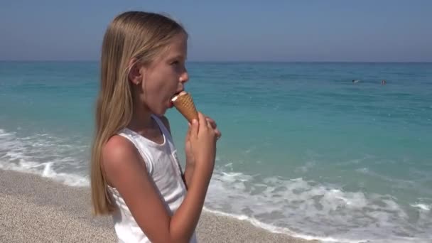 少女夏の海岸の夕暮れビーチでアイスクリームを食べる子 — ストック動画