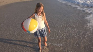 Kumsalda gün batımında, deniz dalgaları kız deniz yürüme çocuk mutlu oynayan çocuk