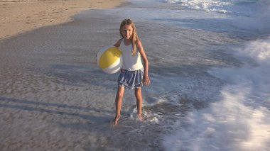 Kumsalda gün batımında, deniz dalgaları kız deniz yürüme çocuk mutlu oynayan çocuk