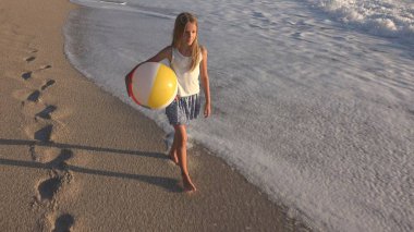 Kumsalda gün batımında, deniz dalgaları kız deniz yürüme çocuk mutlu oynayan çocuk