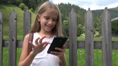 Smartphone açık, oynayan çocuk çocuk tablet, kız doğada rahatlatıcı