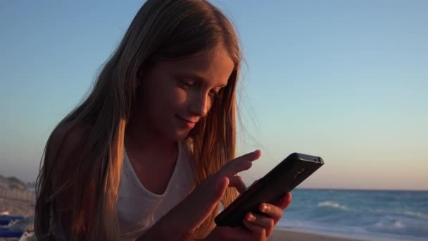 Barnlek Smartphone Kid Stranden Vid Solnedgången Flicka Med Surfplatta Stranden — Stockvideo