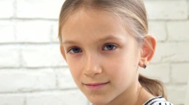 Portre gülümseyerek, mutlu bir çocukluk yüz kamerada, sarışın kız arıyorsunuz oynamak çocuk