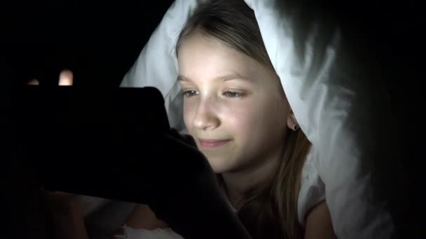 儿童玩平板电脑在黑暗的夜晚 女孩浏览互联网在床上 而不是睡觉 — 图库视频影像
