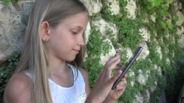 Smartphone açık, oynayan çocuk çocuk tablet, kız doğada rahatlatıcı