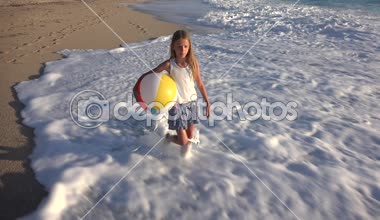 Kumsalda gün batımında, deniz dalgaları kız deniz yürüme çocuk mutlu oynayan çocuk