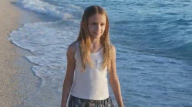 Kumsalda gün batımında, deniz dalgaları kız deniz yürüme çocuk mutlu oynayan çocuk