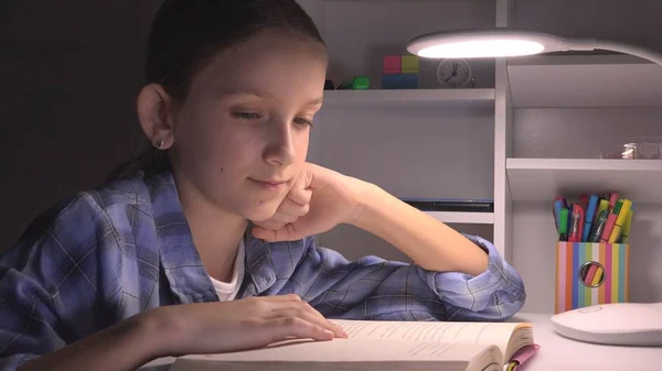 Ανάγνωση παιδιών τη νύχτα, κορίτσι του σχολείου που σπουδάζει στο σκοτάδι, παιδί που μαθαίνει, εργασία στο σπίτι — Φωτογραφία Αρχείου