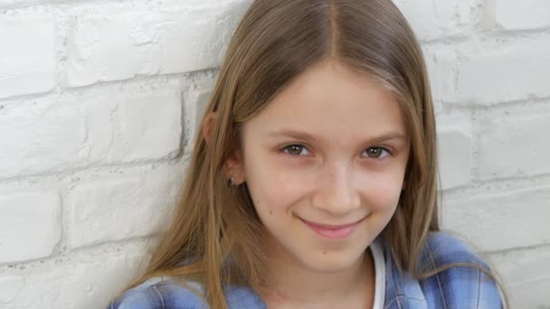 Retrato infantil reflexivo, cara de niño sonriente mirando en la cámara chica aburrida rubia — Vídeos de Stock