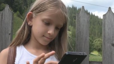 Smartphone Tablet, kız doğada rahatlatıcı açık, çocuk tarama oynayan çocuk