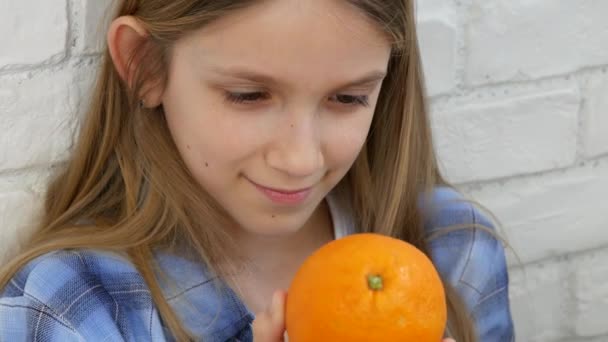 子供は朝食時にオレンジ果物を食べる、女の子の子供は健康的な食品キッチンを嗅ぐ — ストック動画