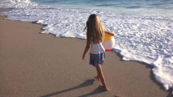 Enfant jouant sur la plage au coucher du soleil, enfant heureux marchant dans les vagues de la mer Fille sur le bord de la mer — Video