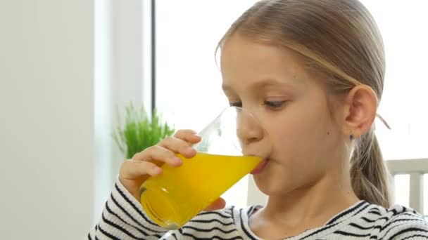 Kind drinken sinaasappelsap, Kind bij het ontbijt in de keuken, Meisje citroen vers — Stockvideo