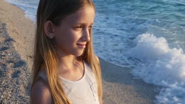 Kind spelen op strand in Sunset, Kid kijken naar zee golven, meisje portret op oever — Stockvideo