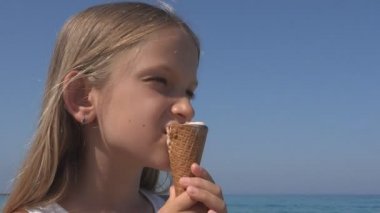 Gün batımında, deniz kıyısı yaz aylarında küçük kız plajda dondurma yeme çocuk