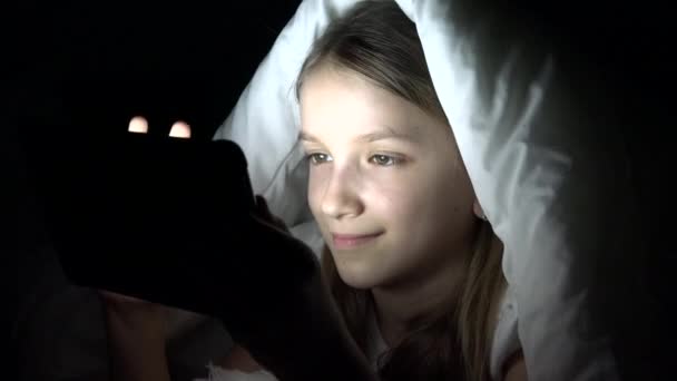 Niño jugando a la tableta en la noche oscura, Niña navegando por Internet en la cama, no durmiendo — Vídeo de stock