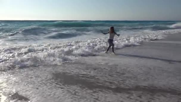 Niño jugando en la playa, viendo olas marinas, Chica corriendo en la costa en verano — Vídeo de stock