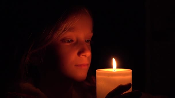 Criança feliz com velas, menina de oração à noite, retrato de criança, rosto no escuro 4K — Vídeo de Stock