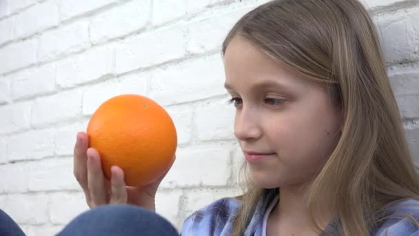 Kind isst Orangen Obst zum Frühstück, Mädchen Kind riecht gesunde Küche — Stockvideo