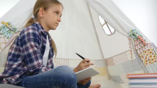 Детский планшет в игровой комнате Девочка пишет домашнюю работу для школьной детской площадки — стоковое видео