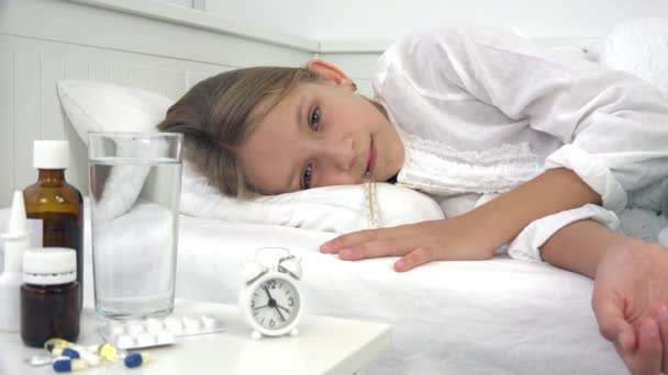 Больной ребенок в постели, больной ребенок с термометром, девочка в больнице, таблетки — стоковое видео