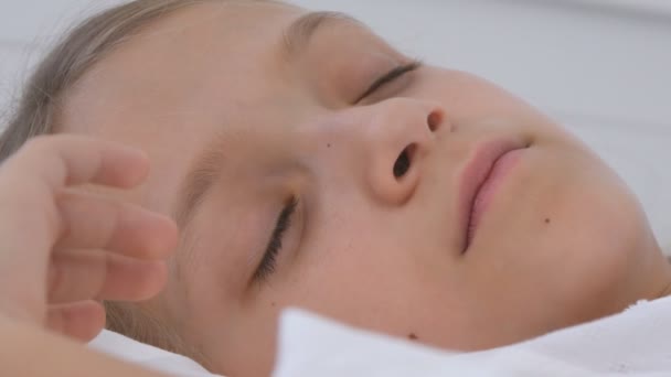 Дитина спить в ліжку, дитячий портрет відпочиває в спальні, обличчя дівчини вдома — стокове відео