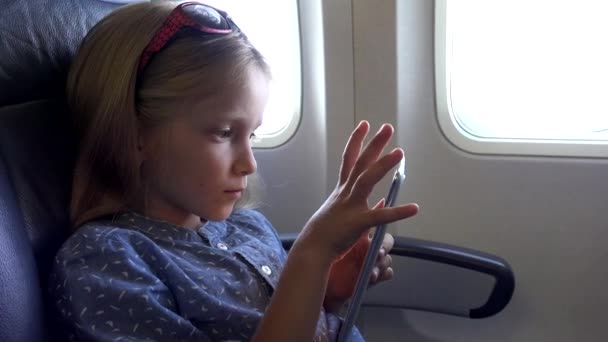 Child Playing Tablet in Plane, Small Girl Portrait Using Smartphones Airplane 4K — Stock Video