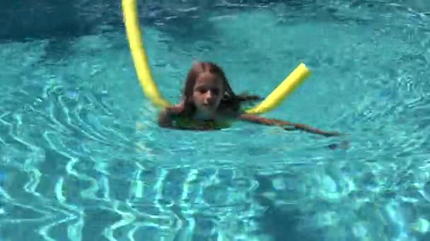 Kind schwimmt im Pool, lächelndes Kind, Mädchenporträt genießt Sommerurlaub — Stockvideo