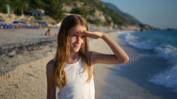 Gyermek játszik strand Sunset, gyerek nézi a tenger hullámai, lány portréja a parton — Stock videók