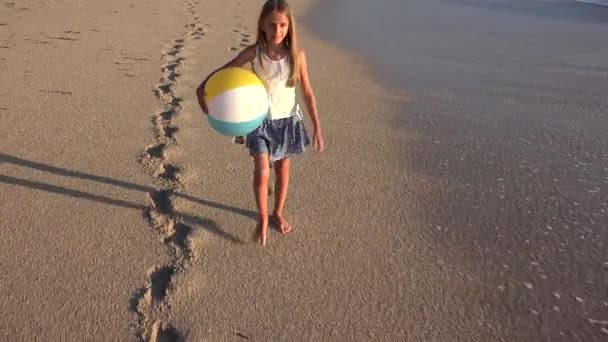 Barn leker på stranden vid solnedgången, Happy Kid promenader i havet vågor flicka vid havet — Stockvideo