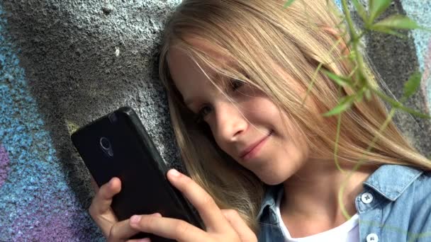 Bambino che utilizza Smartphone, Bambino che gioca su Smart Phone, Ragazza all'aperto nel parco — Video Stock