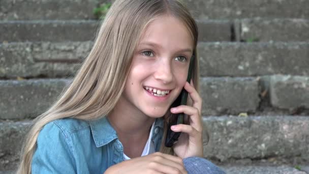 Criança conversando no smartphone, criança usando telefone inteligente, menina jogando ao ar livre no parque — Vídeo de Stock