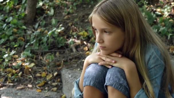 Грустное дитя, не играющее в одиночку, несчастная задумчивая девушка на природе в парке — стоковое видео