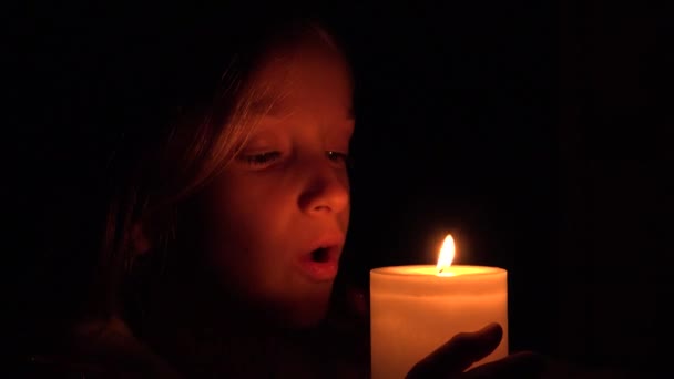 Šťastné dítě se svíčkami, modlitba dívka v noci, dítě portrét, tvář v tmavých 4k — Stock video
