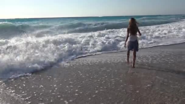 Kind Playing op strand, zee golven, kijken meisje draait op de kustlijn in de zomer — Stockvideo