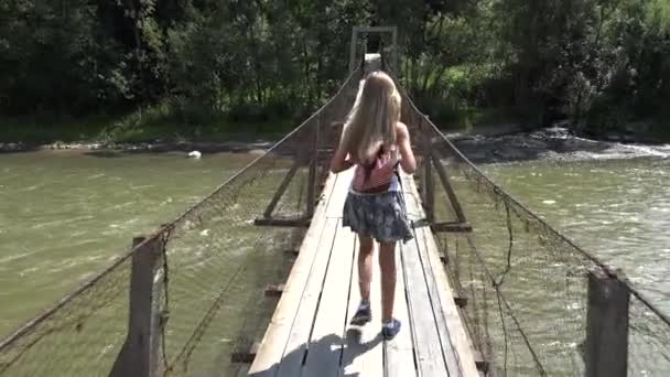 Criança na Ponte nas Montanhas, Kid Caminhadas na Natureza, Menina Olhando um Rio, Fluxo — Vídeo de Stock