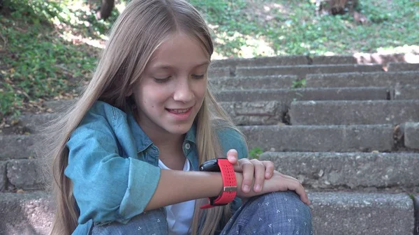 Smart Watch, Kind benutzt Smartwatch im Park, Kind spricht am Smartphone — Stockfoto