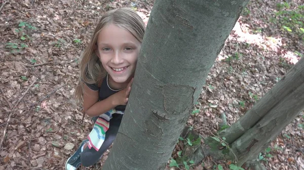 Dítě v lese, Kid hraje v přírodě, Dívka v dobrodružství venku za stromem — Stock fotografie