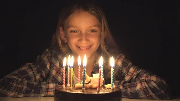 Festa de aniversário da criança soprando velas na noite, celebração do aniversário das crianças — Fotografia de Stock