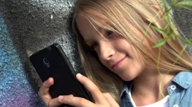 Akıllı telefon kullanan çocuk, Akıllı Telefon 'da oynayan çocuk, Park' ta gezen kız.