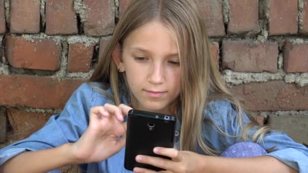 Kid using Smartphone, Child Playing on Smart Phone, Girl Outdoor in Park — Stock Video