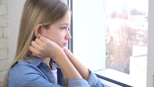 悲しい子供窓を見て、不幸な子供、退屈した思考の少女、十代の顔の悲しみ、コロナウイルスの危機のために自宅で隔離された人々 — ストック動画