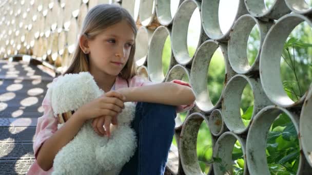 Triste niño en parque, infeliz pensativo niño al aire libre, aburrido chica pensativa en puente — Vídeos de Stock