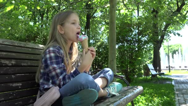 Niña comiendo helado, Niña en el patio de recreo, Niña relajándose sentada en el banco al aire libre en el parque 4K — Vídeos de Stock