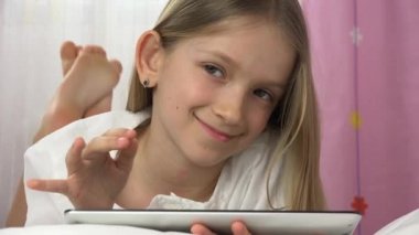Çocuk yatakta tablet oynuyor, çocuk internette geziniyor, kız portresi bilgisayarda dinleniyor, genç yaşta uyumuyor.